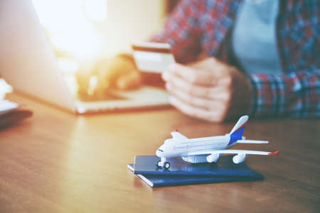 Airplane with passports near paying with credit card  and laptop. Online ticket booking conceptの写真素材