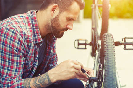 man repairing bike with screwdriverの写真素材