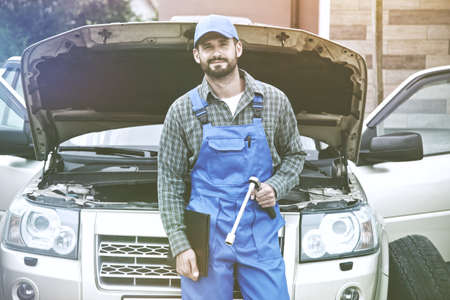 Portrait of auto mechanic working with wrench in engine. Car repair serviceの写真素材