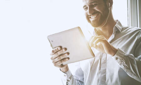 smiling businessman with digital tablet and earphones