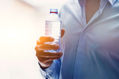 mans hand with bottle of water in sunlightの写真素材