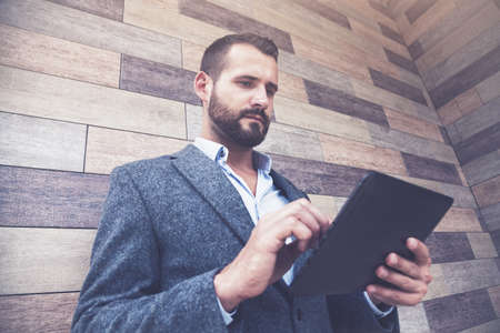 handsome businessman holding digital tablet touching with fingerの写真素材