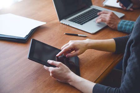 man and woman working together with digital tablet and laptop