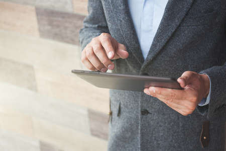 handsome businessman holding digital tablet touching with fingerの写真素材