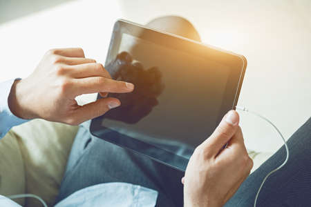 male hands holding digital tablet touching with fingerの写真素材