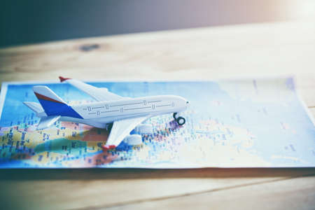 Plane model with world map as airplane traveling concept