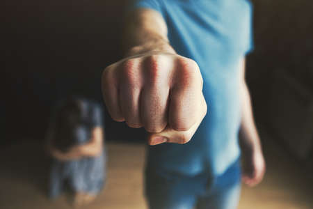 Scared woman protecting from mans aggression. Domestic violence concept