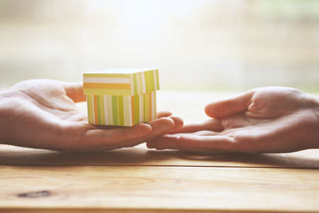 two hands of loving couple with gift boxの写真素材