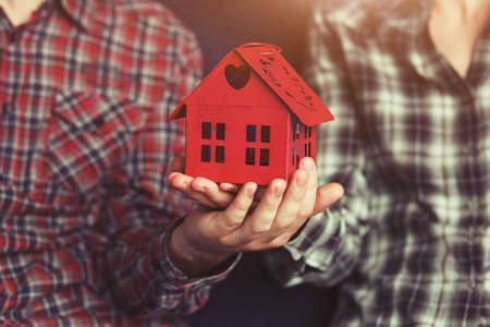 young loving couple holding in hands symbol of home and houseの写真素材