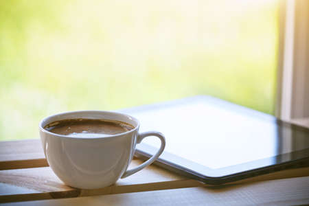 Cup of morning coffee with tablet computerの写真素材