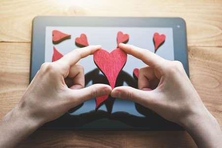 hand collecting hearts as like symbol in social media for posts and photosの写真素材