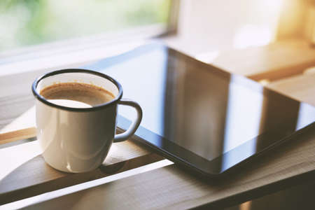 Cup of morning coffee with tablet computerの写真素材