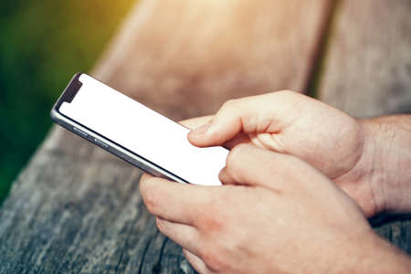 Hands using smart phone touching screen with fingers. White blank screen