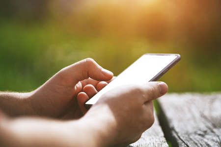 Hands using smart phone touching screen with fingers. White blank screen