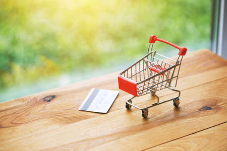 toy trolley with credit card as symbol of shopping and payingの写真素材