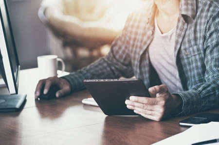 man with digital tablet and computer at workplaceの写真素材