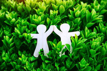 Wooden little men holding hands. Teamwork, environment and ecology conceptの写真素材