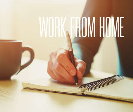 hands with pen writing on notebook and text Work from home. Home isolation and quarantine during coronavirus covid-19 pandemic.の写真素材