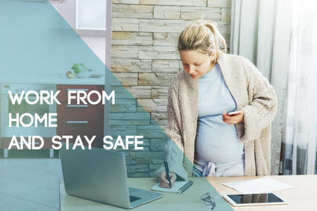Pregnant woman with belly working with laptop and writing and text Work from home and stay safe. Home isolation and quarantine during coronavirus covid-19 pandemic.の写真素材
