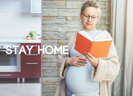 Pregnant woman with belly reading book and text Stay home. Home isolation and quarantine during coronavirus covid-19 pandemic.の写真素材