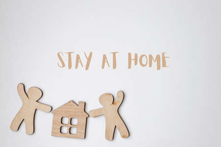 Little wooden men and house with text Stay home. Home isolation and quarantine during coronavirus covid-19 pandemic.の写真素材