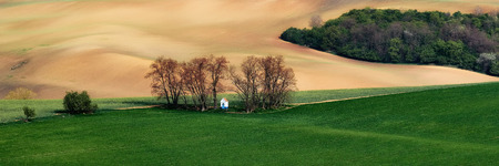 Panorama of beautiful colorful autumn landscape with white chapel st barbara in curved fields.South Morsvia. Czech Republic.の写真素材
