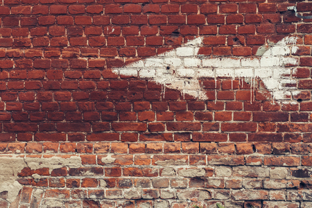 white arrow painted on red brick wallの写真素材