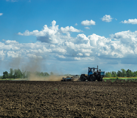 Agricultural Landscape - Tractor working on the field - spring sunny dayの写真素材