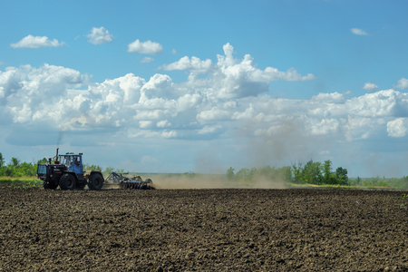 Agricultural Landscape - Tractor working on the field - spring sunny dayの写真素材