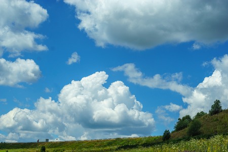 Bright blue sky with high clouds, natural scenery, the road on the hillの写真素材