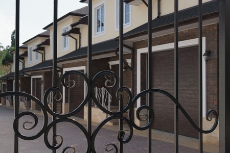 new townhouses behind the bars of iron gateの写真素材