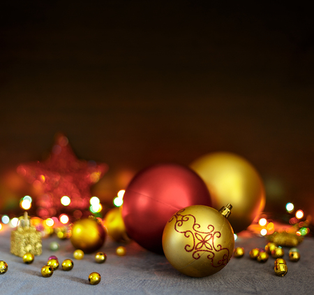 Yellow and red Christmas balls and holiday decorations are on the table with dark background free space.の写真素材