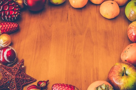 Fresh fruits and Christmas decorations from above with copy space. Top view. Toned image.の写真素材
