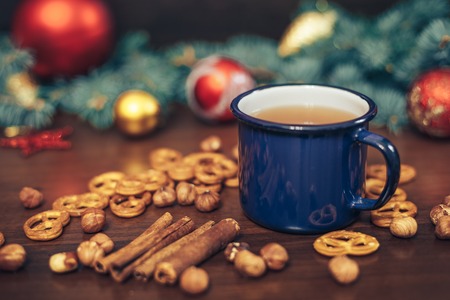 vintage Cup of hot tea with crackers on wooden background decorated with pine brunches and christmas toys, christmas conceptの写真素材