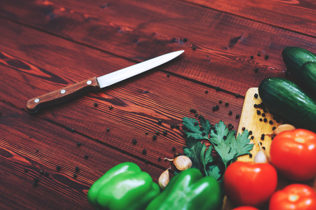 kitchen workplace concept. fresh vegetables, spices and knife on wooden table backgroundの写真素材