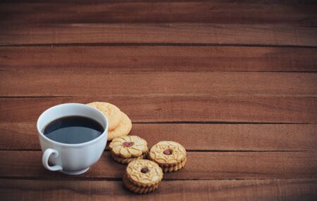 Cup of hot coffee and cookies on wooden background. copy space for textの写真素材