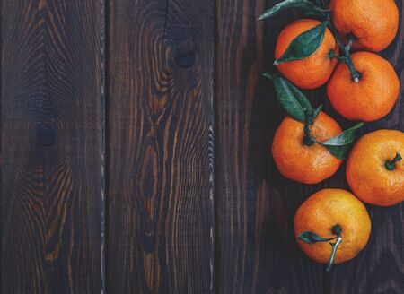 fresh juicy ripe tangerines with leaves on wooden background closeup. top view. health  organic vegetarian diet concept. winter mandarin. copy spaceの写真素材