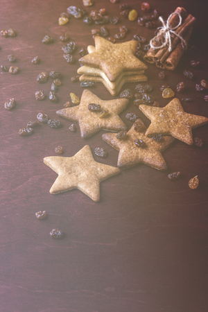 Close up of homemade ginger cookies, cinnamon with raisins on a red wooden table. Copy space. Vertical Retro toned imageの写真素材