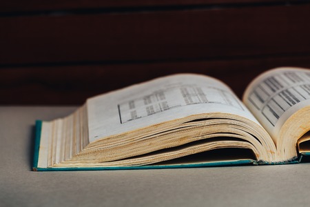 Open book. Dark background . Back to school or library. Copy space. Toned retro image.の写真素材