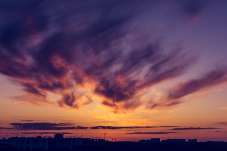 Colorful dramatic sunset in purple tones with feather cloudsの写真素材