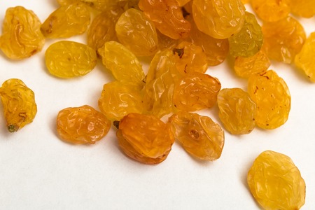 Macro photo of organic dried golden raisins on white background