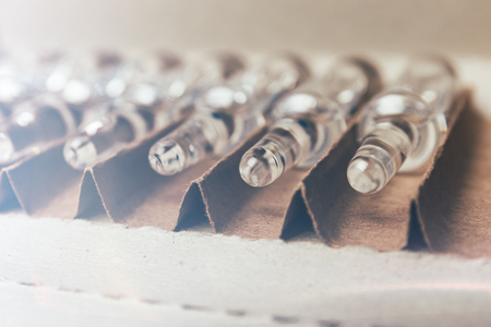 Glass medical ampoules with medicine in an open box, ready for injectionの写真素材