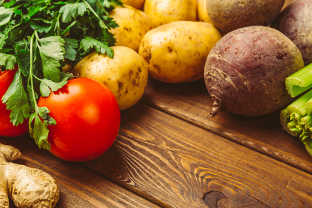 Fresh raw organic vegetables on a wooden background: tomatoes, potatoes, parsley, beets. Healthy food conceptの写真素材