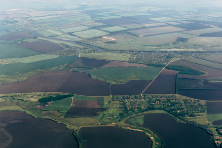 Aerial view from airplane, earth, green fields, roads, villages landscape