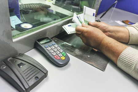 Man receives money in a bank, men's hands count the cash notes for 100 euros. Finance concept