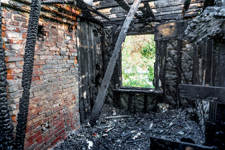 Interior of a burnt by fire apartment in an abandoned building. Burned wooden and brick wallsの写真素材