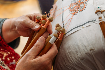 Needlework concept, old craft woman makes bobbin lacing or Palickovanie - Folk art, hobby, hand made product creatingの写真素材
