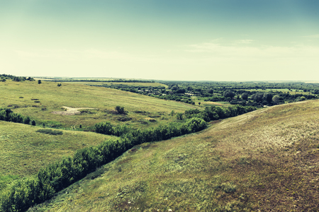 Panorama of a natural landscape, retro toned. Green hills, plain to the horizonの写真素材
