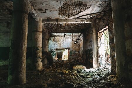 Dark hall of ruined abandoned factory with columns, tonedの写真素材