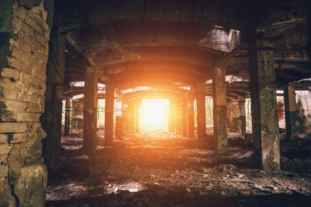 Abandoned warehouse with columns, dark tunnel perspective with bright light in the end, tonedの写真素材
